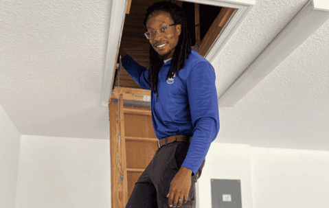 Native pest technician inspecting attic