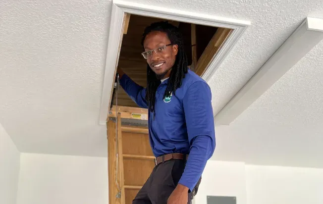A technician on a ladder to the attic